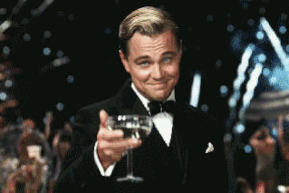 Leonardo DiCaprio in tuxedo raising his champagne glass to toast (The Great Gatsby)